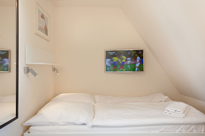 Schlafbereich mit Doppelbett und TV